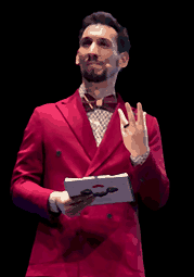 Nicola in pixel art sul palco del Cantafestival: giacca rossa, papillon, un foglio in mano e l'altra alzata verso il pubblico.
